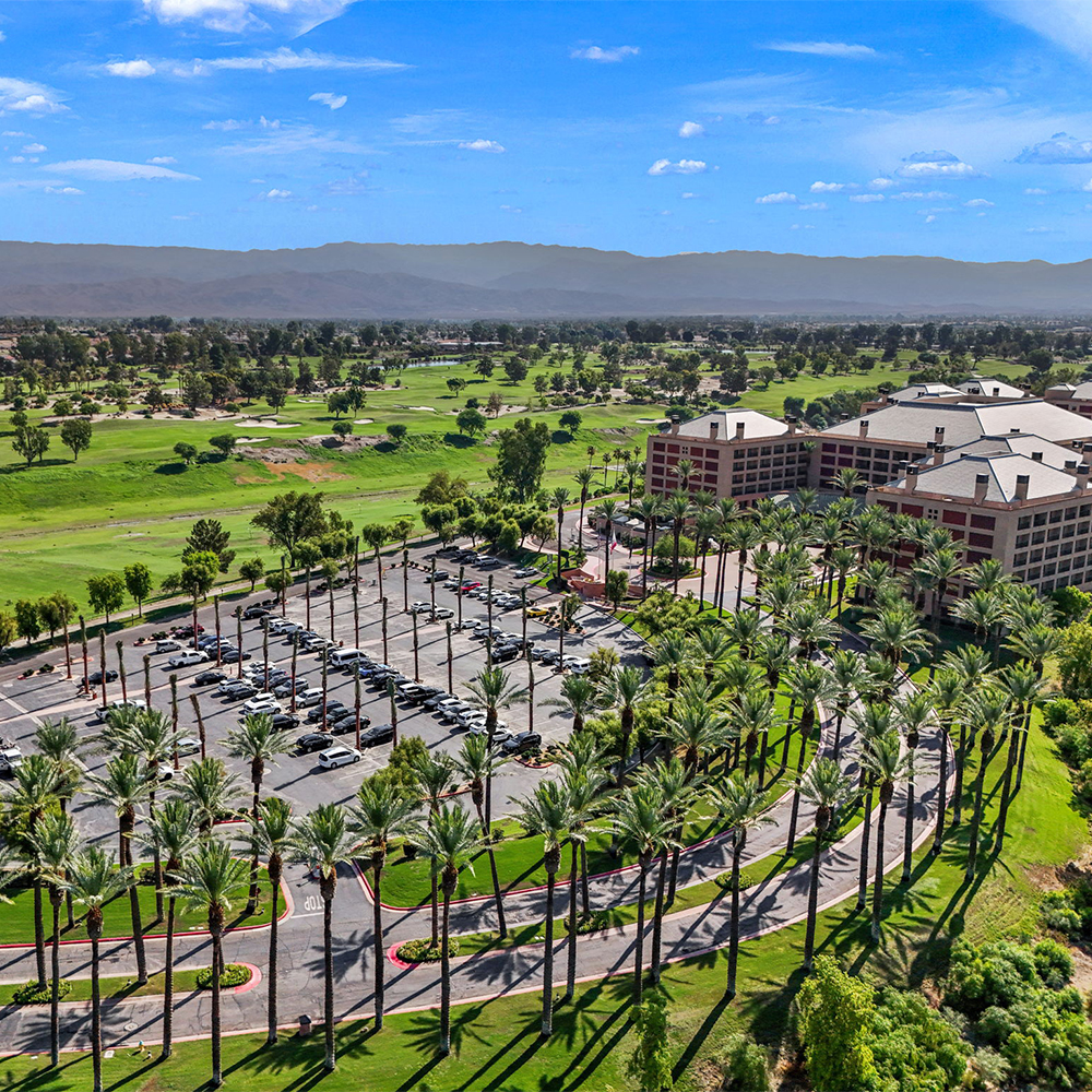 beautiful overhead view of a building, and campus surrounded by palm trees